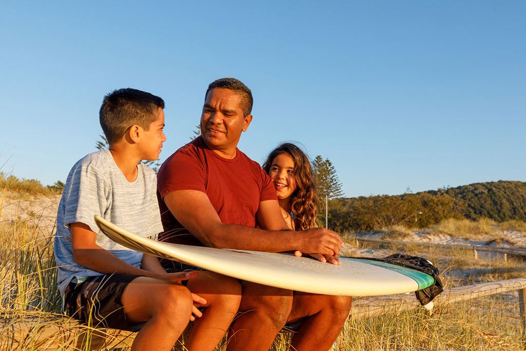 Father and two kids ready to go surfing