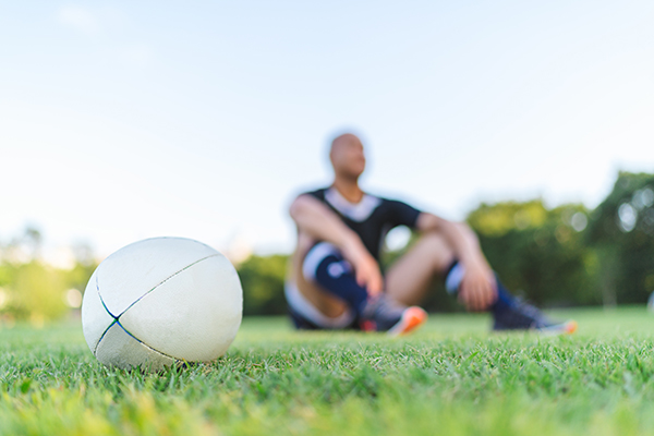 Rugby player sitting on a field